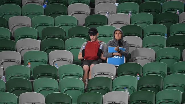 A pair of hardy fans watch the women’s fourth-round match on Rod Laver Arena. Picture: AFP