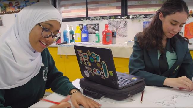 Islamic College of Brisbane’s Rania Shahzad with Ferny Grove State High School’s Sonya Gerstel in an art class at ICB, where students are not allowed to draw faces or eyes. PHOTO: Supplied