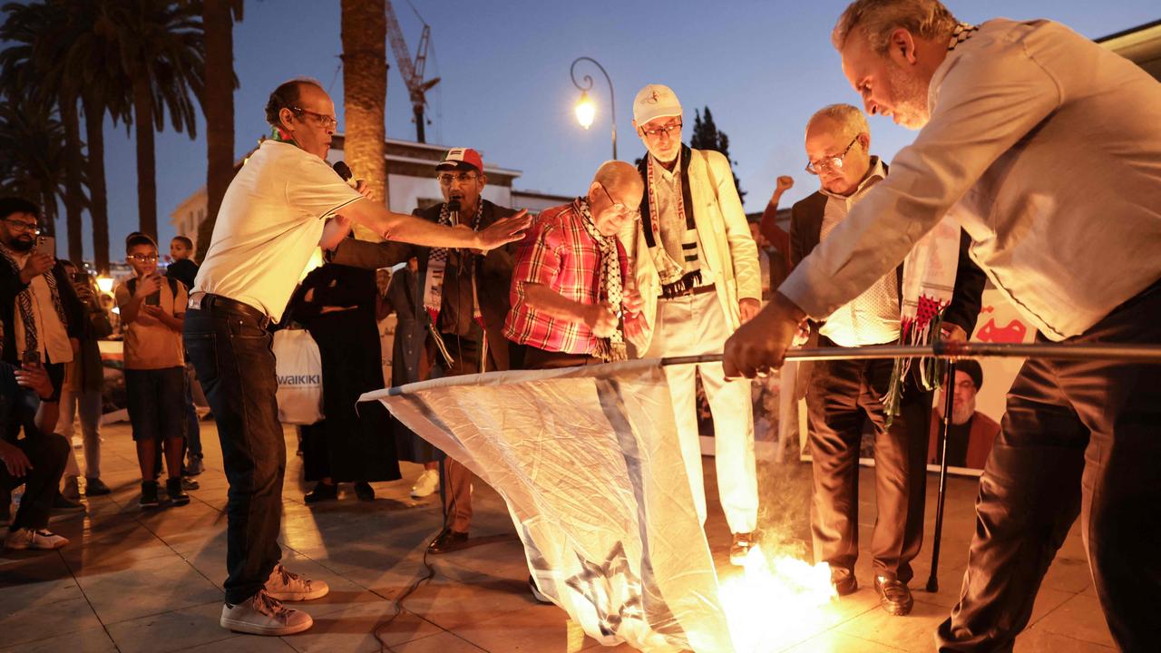 Demonstrators burn an Israeli flag in front of the parliament building, following the assassination of Lebanon's Hezbollah leader Hassan Nasrallah, in Rabat on September 28. Picture: AFP