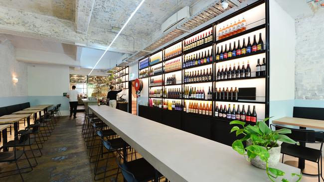 A wall of wine brightens the monochromatically cool dining room at Cheek. Picture: Nicki Connolly