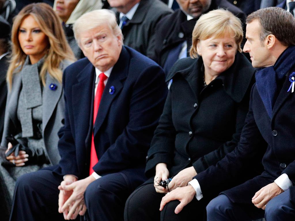 Donald Trump was a bit like a third wheel between Emmanuel Macron and Angela Merkel in Paris. Picture: AFP