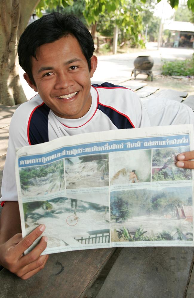 Yai Kaytmunnee (20), with the newspaper showing him being swept away by the tsunami, at his home town village, Nar Kun Sen, Thailand. Picture: Michael Perini.