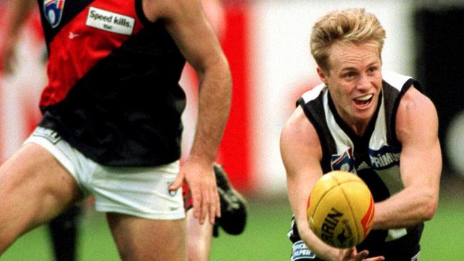 Magpie Brad Fuller handballs against Essendon in 1998.