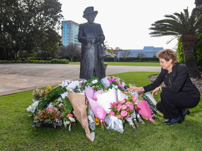 Governor Frances Adamson looks at flowers at the base of the statue of Queen Elizabeth II at Government House. Picture: Brenton Edwards