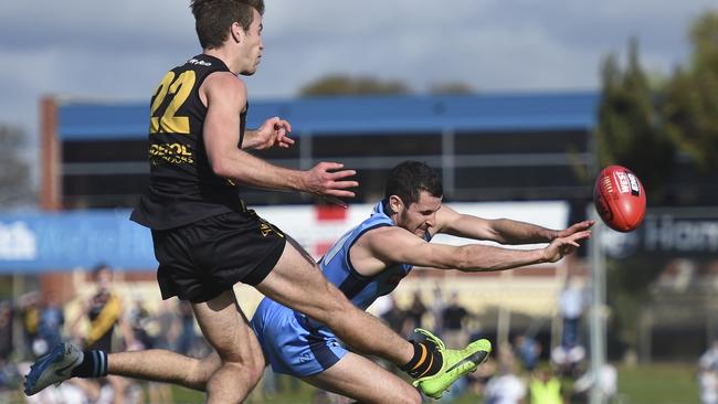 Sturt's Matthew Crocker attempts to smother the kick of Glenelg's Chris Curran. Picture: Naomi Jellicoe