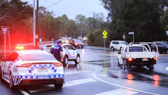 Queensland Police at the intersection of 19th Avenue and Guineas Creek Road to warn drivers about flood waters after the Tallebudgera Creek burst its banks. Photo: Scott Powick