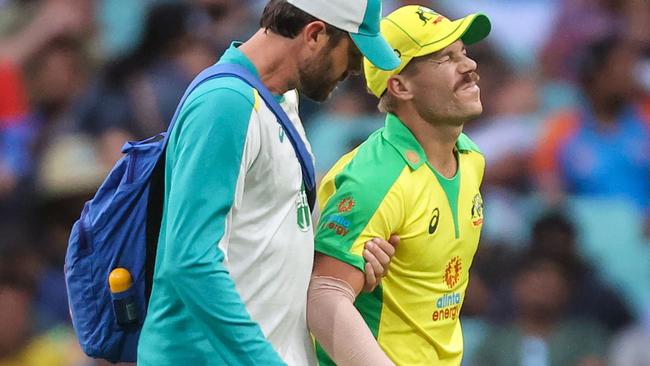 David Warner is helped from the SCG after hurting his adductor on Sunday. Picture: David Gray / AFP