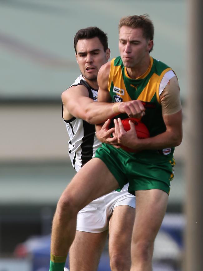 Sale’s Jack Leslie arrives late to spoil Leongatha’s Jack Hume. Picture: Yuri Kouzmin