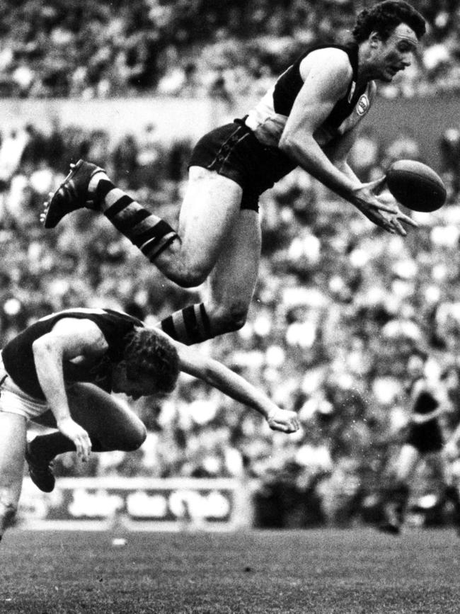 Michael Roach flies high over Phil Maylin in 1982.