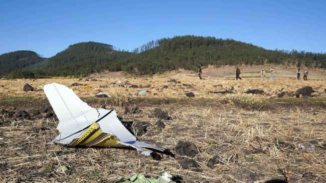 ADDIS ABABA, ETHIOPIA - MARCH 10: A piece of the fuselage of ET Flight 302 can be seen in the foreground as local residents collect debris at the scene where Ethiopian Airlines Flight 302 crashed in a wheat field just outside the town of Bishoftu, 62 kilometers southeast of Addis Ababa on March 10, 2019 in Addis Ababa, Ethiopia. Flight 302 was just 6 minutes into its flight to Nairobi, Kenya, when it crashed killing all 157 passengers and crew on board. The cause of the crash has not yet been determined. (Photo by Jemal Countess/Getty Images)