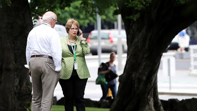 Speaker Sue Hickey, with her chief of staff Mervin Reed, talking on the phone on Parliament Lawns after voting against the Government for the first time. Picture: LUKE BOWDEN