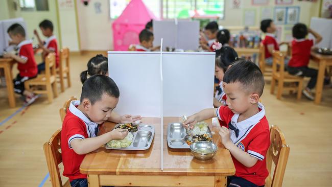 Plastic partitions separate children at lunch time at a kindergarten in Yongzhou in China's central Hunan province. Picture: AP