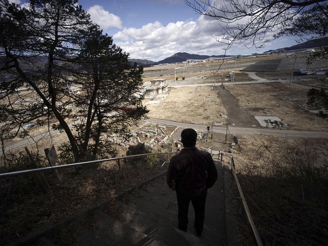 Michihiro Kono looks from a hill at the site of his company's headquarters was located before the 2011 tsunami.