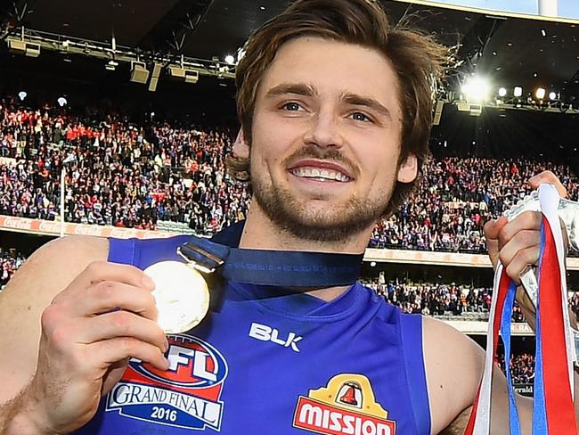 MELBOURNE, AUSTRALIA - OCTOBER 01: Joel Hamling and Fletcher Roberts of the Bulldogs of the Bulldogs celebrates with the trophy after winning the 2016 AFL Grand Final match between the Sydney Swans and the Western Bulldogs at Melbourne Cricket Ground on October 1, 2016 in Melbourne, Australia. (Photo by Quinn Rooney/Getty Images)