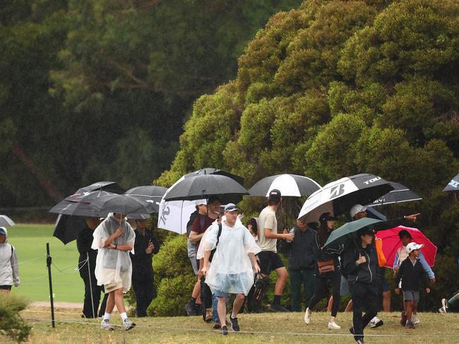 Spectators shelter from the rain on day three of the ISPS Handa Australian Open 2024 at Kingston Heath Golf Club in Heatherton. Picture: Morgan Hancock