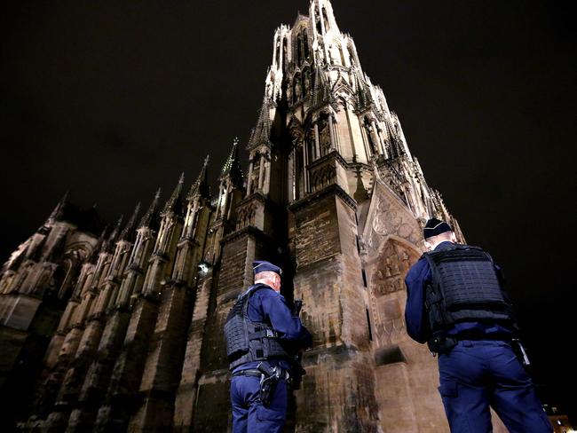 Police stand guard outside the Notre-Dame de Reims cathedral in Reims, during a "mass for France" in homage to the three victims of a knife attack. Picture: AFP