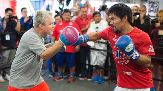 Pacquiao hits the pads with Roach.