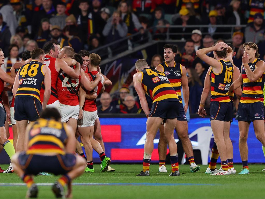 ADELAIDE, AUSTRALIA - APRIL 19: Players react on the siren with Essendon celebrating and Crows player slump after the loss during the 2024 AFL Round 06 match between the Adelaide Crows and the Essendon Bombers at Adelaide Oval on April 19, 2024 in Adelaide, Australia. (Photo by Sarah Reed/AFL Photos via Getty Images)