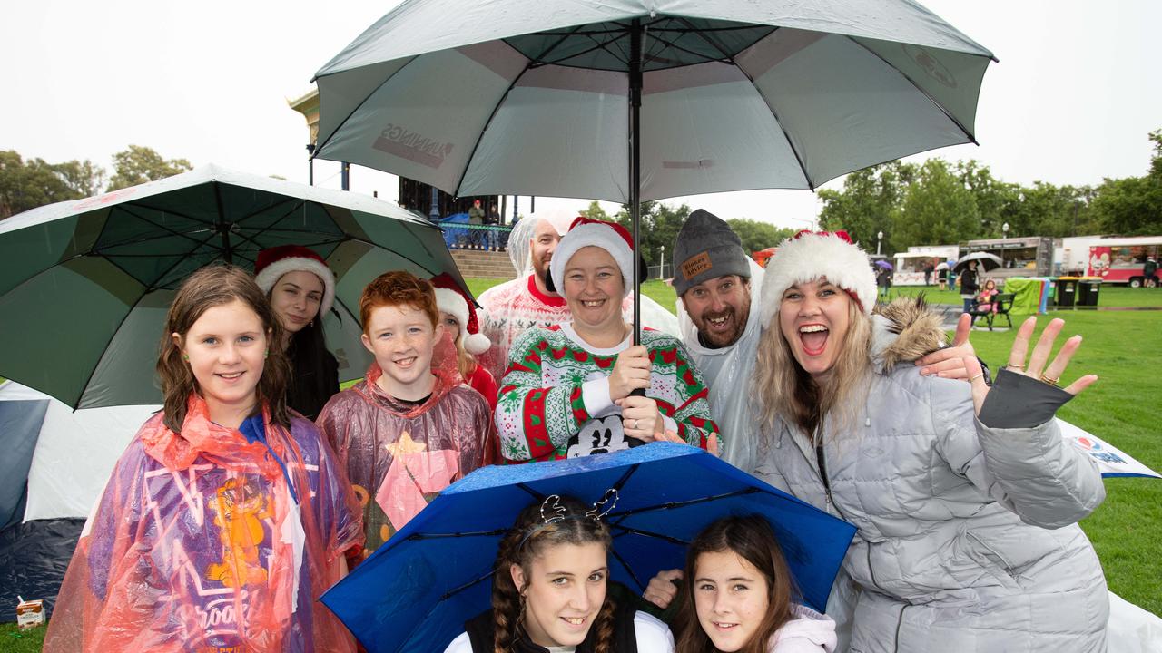 The White family braves the weather to attend Sealink Carols by Candle Light at Elder Park. Picture: Brett Hartwig