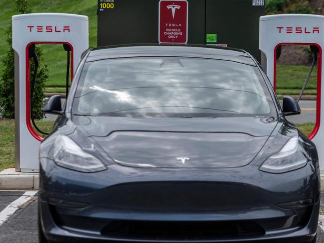 (FILES) In this file photo taken on August 13, 2021 Cars charge at a Tesla super charging station in Arlington, Virginia on August 13, 2021. - Electric car maker Tesla will recall nearly 54,000 vehicles in the US to end a feature that allows the cars to go through a stop sign without fully stopping. This "rolling stop" feature in cars equipped with full self-driving software allowed the vehicles "to travel through an all-way stop intersection without first coming to a stop," which "can increase the risk of a crash," the National Highway Traffic Safety Administration said in a letter on January 31, 2022. (Photo by ANDREW CABALLERO-REYNOLDS / AFP)