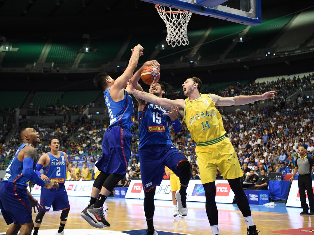 Australia's Angus Brandt (#14) rebounds against June Fajardo (C) of the Philippines during their FIBA World Cup Asian qualifier game at the Philippine arena in Bocaue town, Bulacan province, north of Manila on July 2, 2018. Australia won by default 89-53. / AFP PHOTO / TED ALJIBE