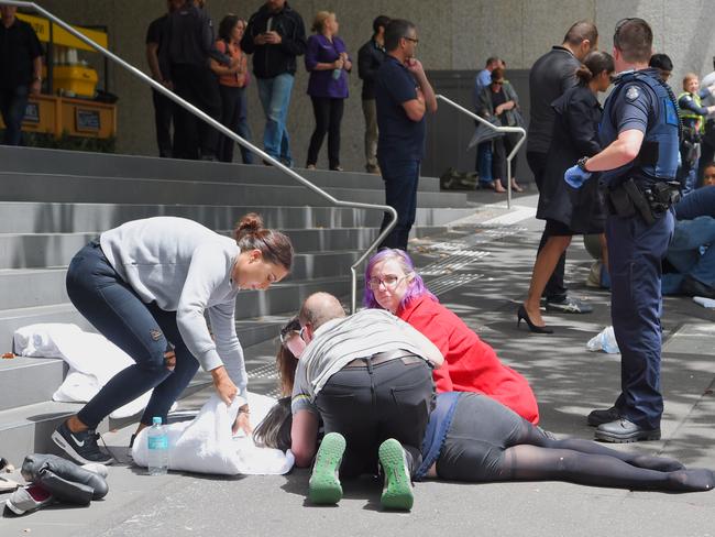 Bystanders rush to aid a victim. Picture: Tony Gough