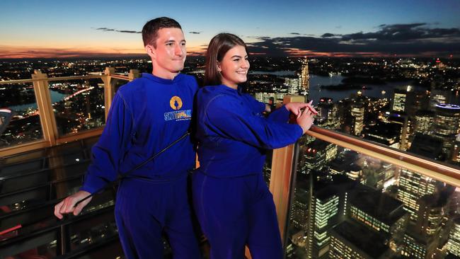 As the sun sets, Chris Pasfield and wife Tiana Hawkins take in the sweeping views on the Sky Walk at the Sydney Tower Eye on Monday. Picture: John Feder