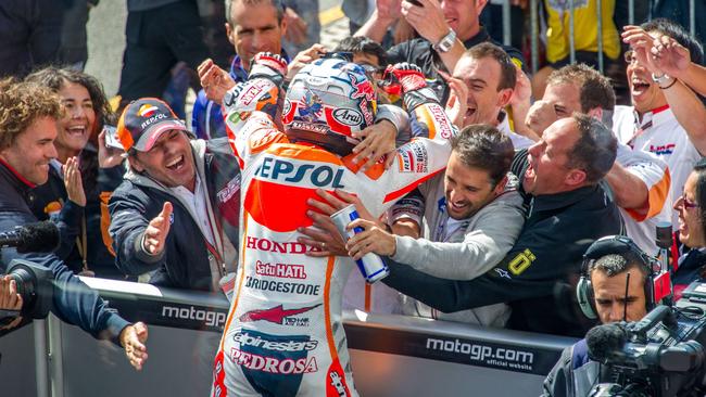 Pedrosa celebrates with mechanics beneath the podium.