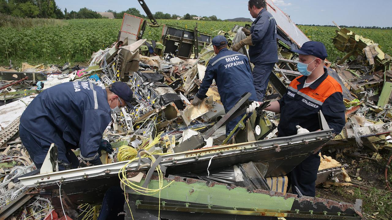 MHC local emergency workers angle grind into the remains of the cockpit of MH17 in 2022, following the downing of the plane by Russian operatives. Picture: Ella Pellegrini