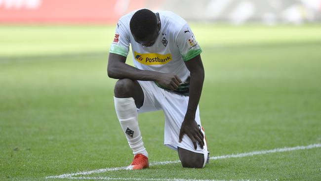 Moenchengladbach's Marcus Thuram takes a knee during a Bundesliga match