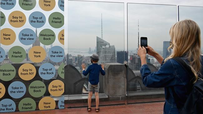 A woman and her son take pictures during the reopening of the Top of The Rock observation deck in New York. Picture: AFP.