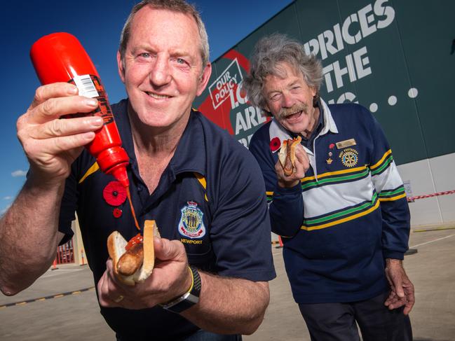 Bunnings Sausage sizzles are back in Melbourne. L-R Ian Nicholls, Newport RSL and Peter O'Brien from West Footscray Rotary Club get stuck into a sausage sandwich at Bunnings in Altona. Picture: Tony Gough