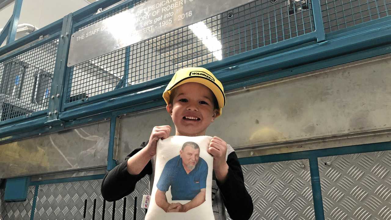 NEW MACHINE: Kyrese Skinner holds up a photo of his grandfather Robert Channing, who had a new composite fibre pultrusion machine unveiled in his honour at the Wagners facility at Wellcamp and (inset) Wagners executive general manager Michael Kemp and Tracey Channing in front of the machine. Picture: Tobi Loftus