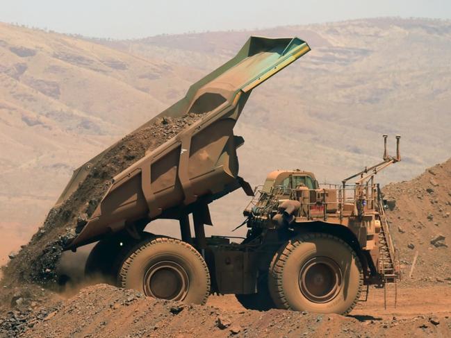 An autonomous haul truck dumps a load of rock in the mine pit at Rio Tinto Group's Gudai-Darri iron ore mine in the Pilbara region of Western Australia, Australia, on Thursday, Oct. 19, 2023. Rio Tinto is preparing for trials of battery-powered locomotives in Australia, where it uses giant autonomous trains — the world’s largest and longest robots — to transport iron ore across the vast Outback. Photographer: Carla Gottgens/Bloomberg