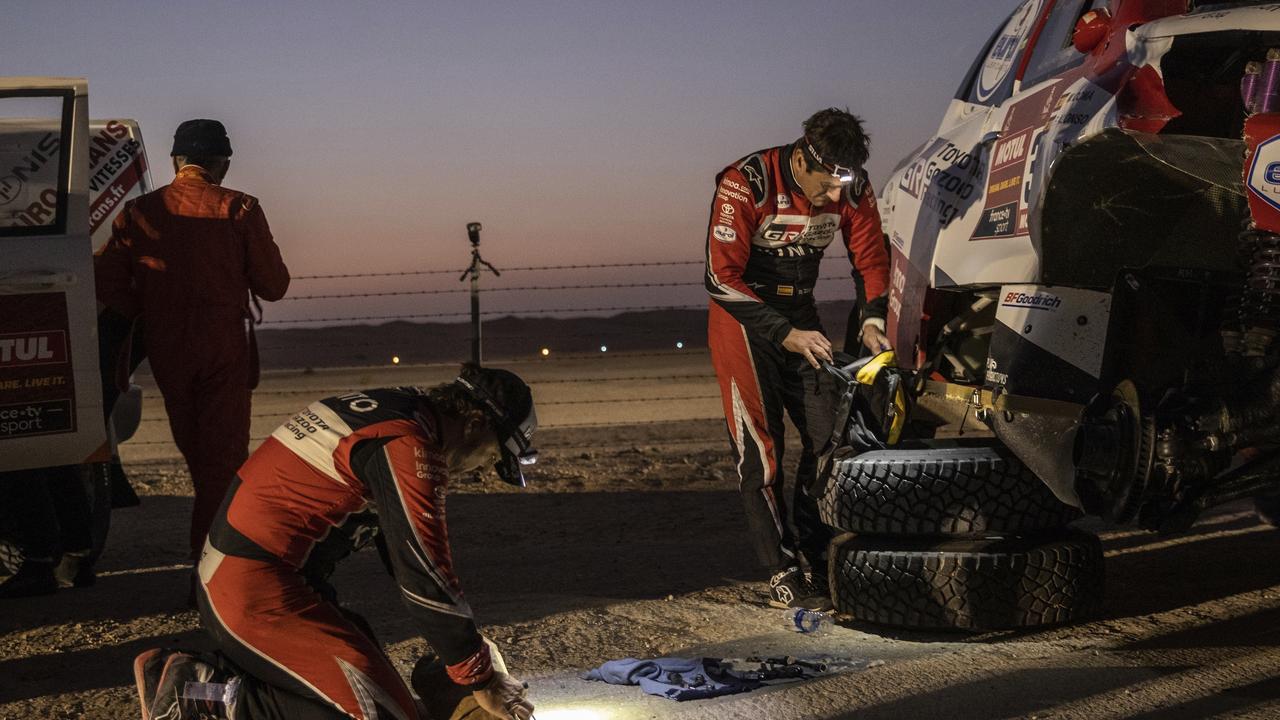 Fernando Alonso and co-driver Marc Coma repair their Toyota after rolling over during Stage 10.