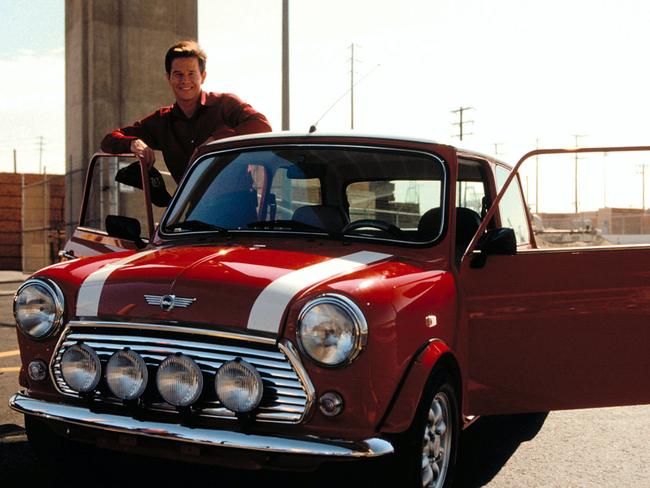 Mark Wahlberg standing next to a mini used in the 2003 film The Italian Job.