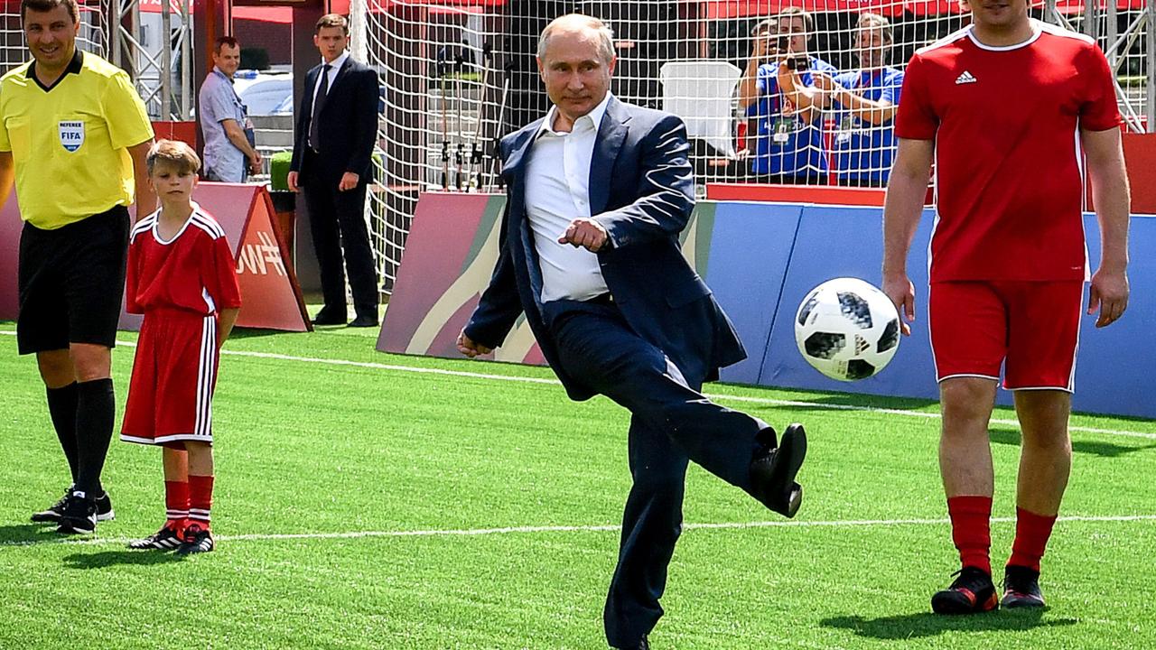 TOPSHOT - Russia's President Vladimir Putin kicks a ball.