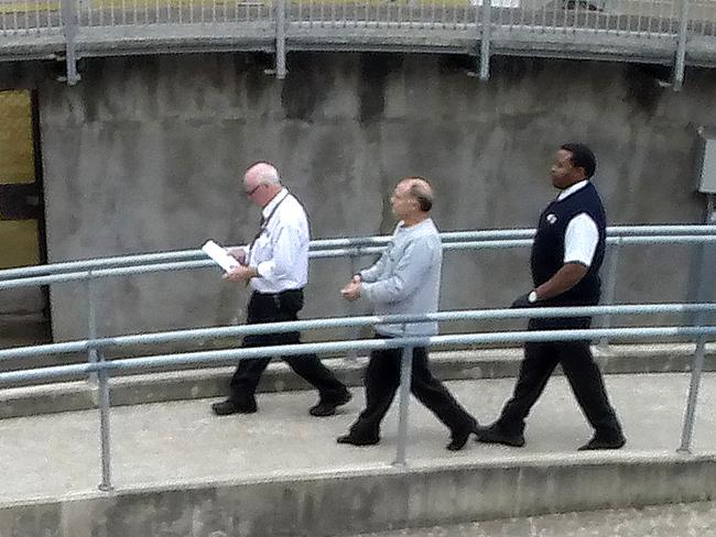 Flanked by security, Dominic Perre, the NCA bombing suspect, is taken into the Adelaide Magistrates Court after his arrest on drug charges. Picture: Greg Higgs