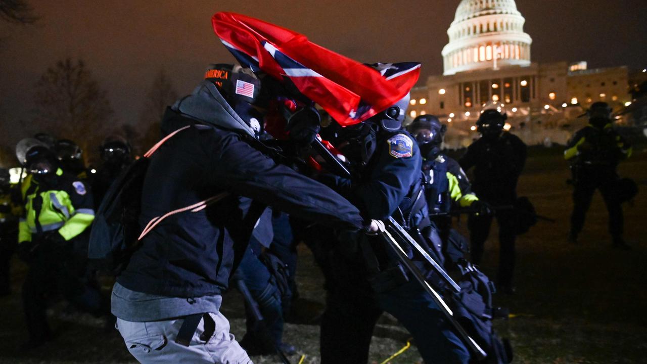 A supporter of US President Donald Trump struggles with a riot policeman after the protester pushed a line of police outside the Capitol building on January 6. Picture: ROBERTO SCHMIDT / AFP.