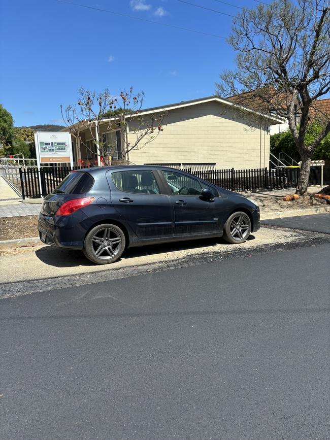 But the road workers ploughed on, laying bitumen around this parked car. Picture: Supplied