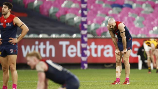 Melbourne players show their disappointment after a draw against Hawthorn.