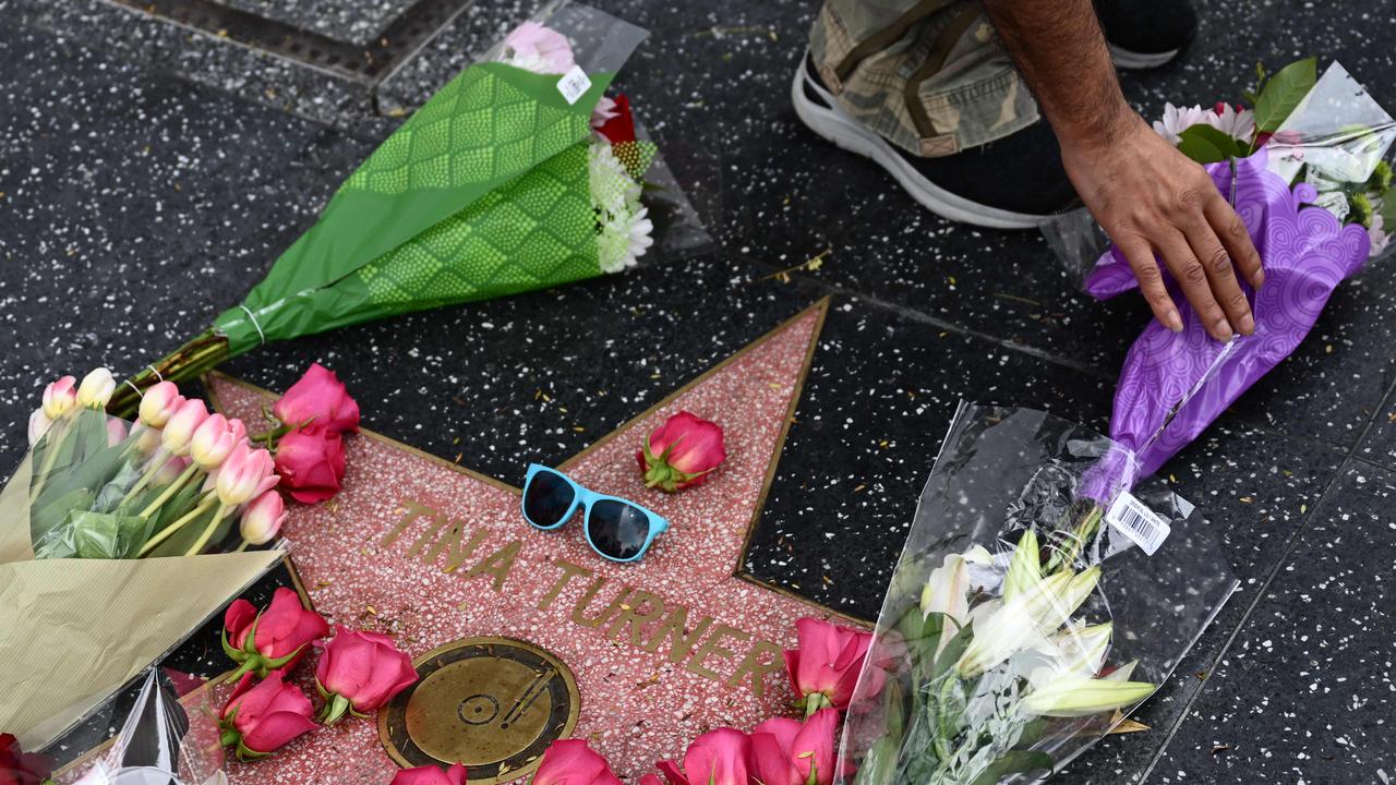 A person places flowers on the Hollywood Walk of Fame star of Tina Turner, in Hollywood, California. (Photo by Patrick T. Fallon / AFP)