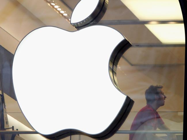 FILE - SEPTEMBER 21: According to reports Apple has approached McLaren, the British super-car maker and Formula One team owner about a potential acquisition. LONDON - DECEMBER 27:  People are seen behind the Apple logo in Apple's flagship London retail store on Regent Street on December 27, 2006 in London, England. With many stores open for the first time since Christmas Eve, bargain hunters are searching for the best buys as the post-Christmas sales get under way. (Photo by Scott Barbour/Getty Images)