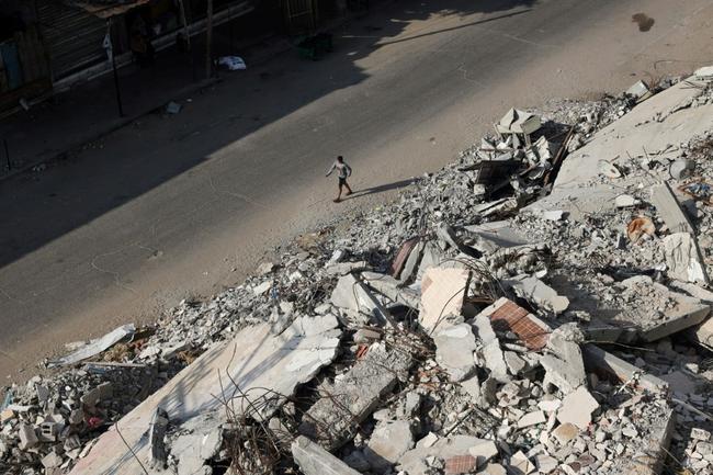 A Palestinian man walks past the rubble of buildings destroyed in Israeli bombardments, in Rafah, in the southern Gaza Strip, on April 30, 2024