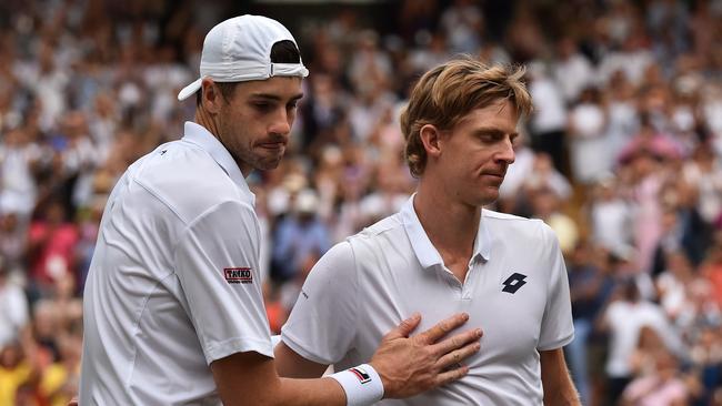 Kevin Anderson of South Africa, right, meets John Isner of the US on the court after defeating him in their men's singles semifinal match at the Wimbledon Tennis Championships, in London, Friday July 13, 2018. (AP Photo/Glyn Kirk, Pool)