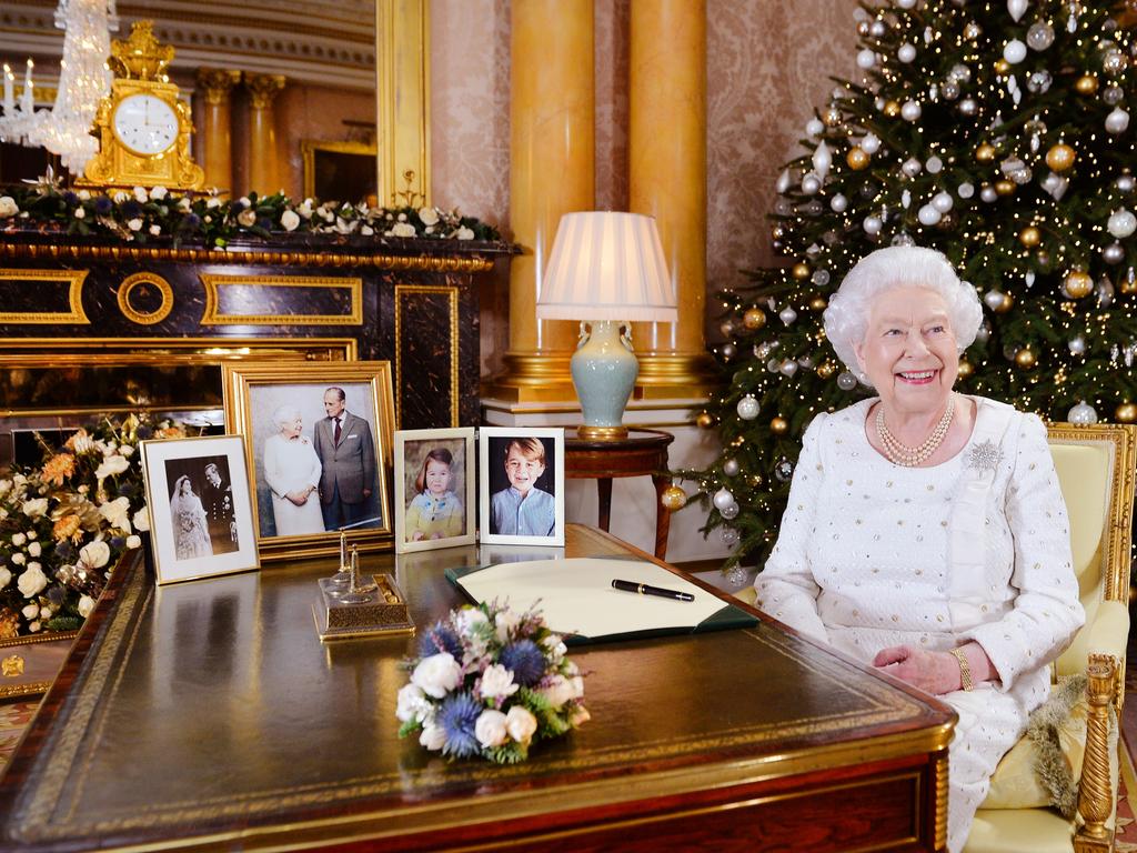 2017: Surrounded by portraits of her family, Queen Elizabeth smiles as she records her Christmas Day broadcast to the Commonwealth at Buckingham Palace, London. Picture: John Stillwell/WPA Pool/Getty Images