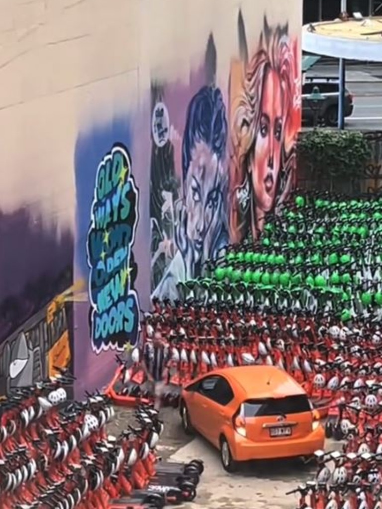 A man navigates hundreds of scooters parked around his car. Picture: TikTok