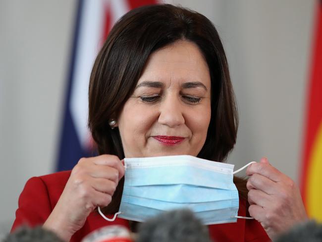 Queensland premier Annastacia Palaszczuk removes her mask at press conference.