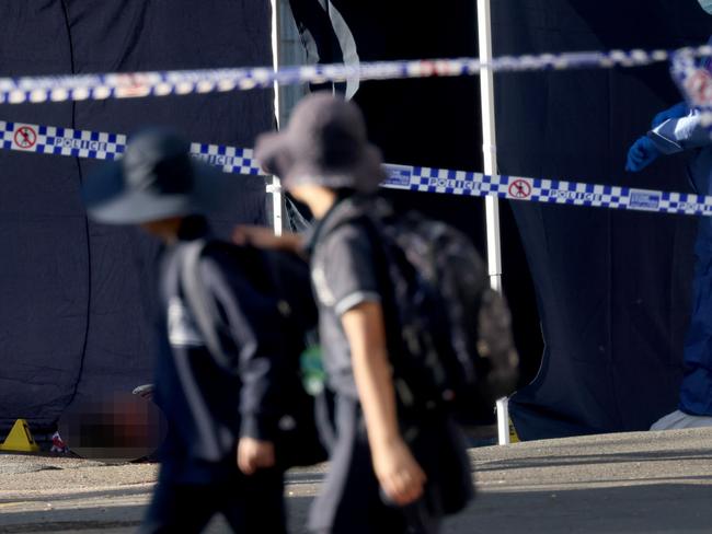 *PIXELATED VERSION*,  *EDITOR'S NOTE*****WARNING GRAPHIC IMAGERY***SYDNEY, AUSTRALIA - NewsWire Photos JULY 27, 2023: School kids walk past Forensics police and a dead body on the ground pictured at a crime scene on Broughton Street in Canterbury where a man was shot dead last night around 2am. Picture: NCA NewsWire