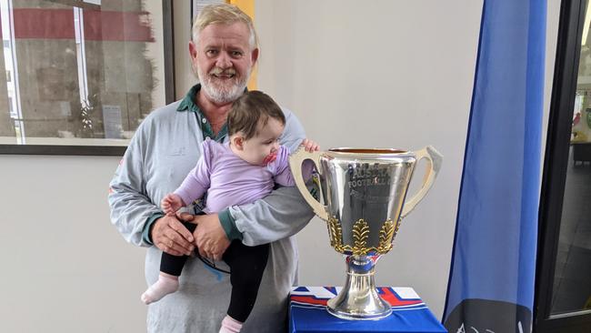 Footy fan Terry Anning with his eight-month-old granddaughter Mia Chester, who is inspecting the 2019 AFL Premiership Cup in Wagga. Picture: Toby Vue